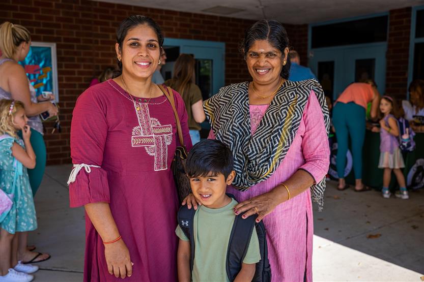 A family of three smiles at Oak View Elementary